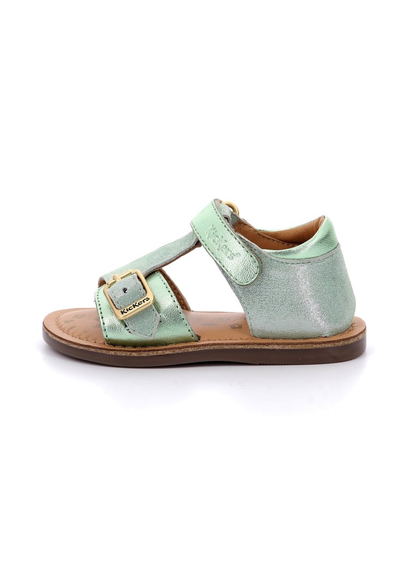 Sandal de cuero verde con un acabado brillante, que presenta una correa de velcro y un detalle de hebilla dorada. Suela plana, diseño abierto en la parte trasera para mayor transpirabilidad.