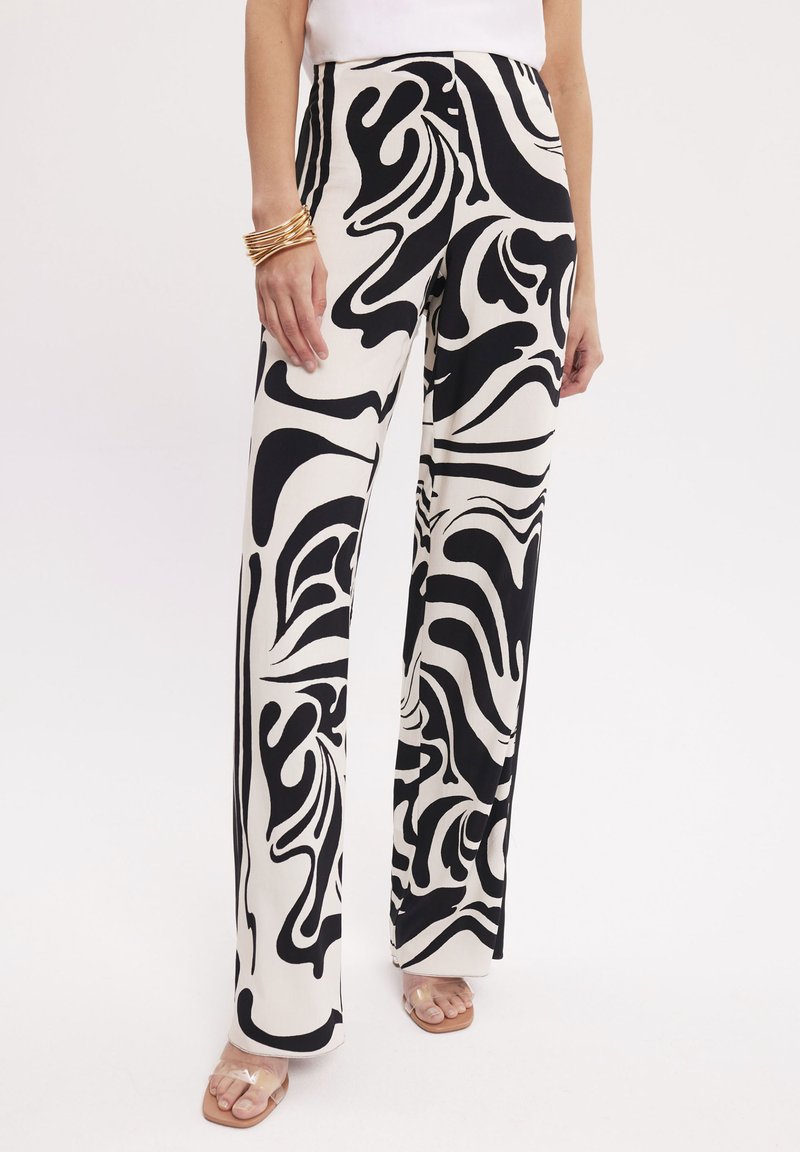 Czarno-białe spodnie o szerokich nogawkach z abstrakcyjnym wzorem w wiry, wykonane z lekkiego materiału, z wysokim stanem i zwiewnym krojem.