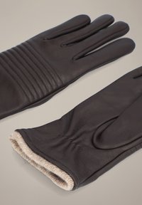 Ciemnobrązowe skórzane rękawiczki z żebrowanym wzorem na grzbiecie i miękkim, jasnobeżowym wykończeniem przy mankiecie. Klasyczny, smukły kształt.