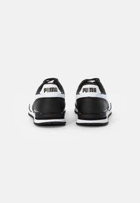 Scarpe da ginnastica in bianco e nero con suola in gomma, parte superiore in mesh e sintetico, dotate di un logo posteriore ben visibile e design della heel imbottita.