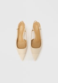 Beiget slingback-korkokengät, joissa on terävä kärki, sileä patenttipinta ja minimalistinen hihnasuunnittelu. Sisäpuolella pehmeä vaaleanruskea pehmuste.