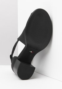 Black heeled sandal with a textured sole, featuring a wide strap design and a solid block heel. Marked with "Made in Italy" and size 37.
