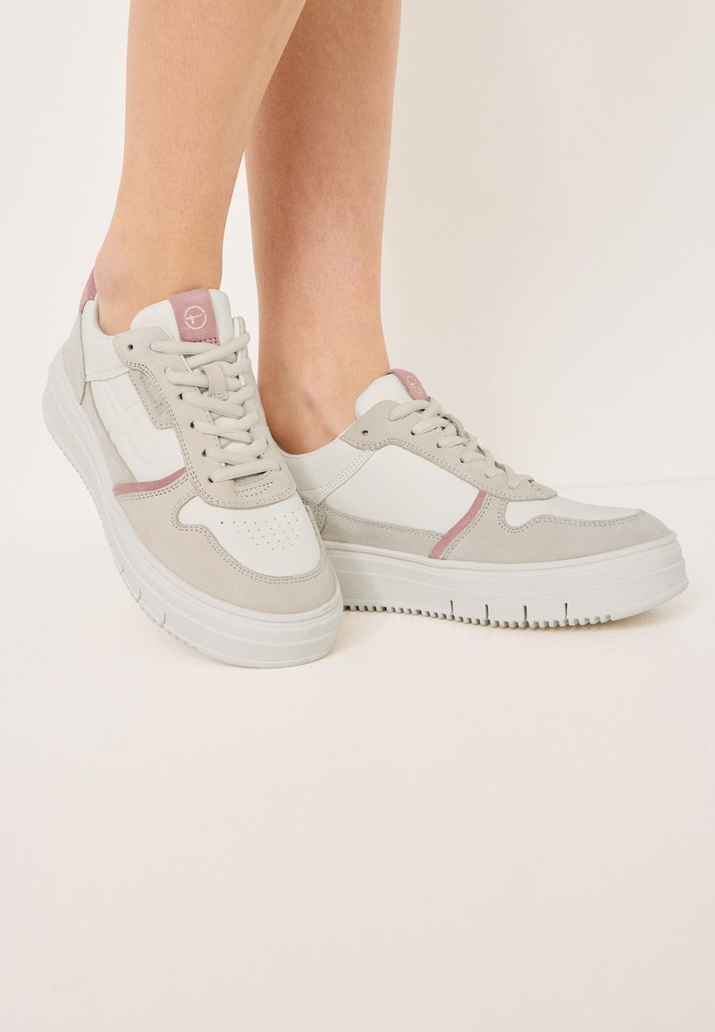 Sneakers z połączeniem białej skóry i jasnoszarego zamszu, z różowymi akcentami, teksturowaną podeszwą i perforowanymi detalami.