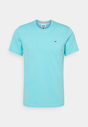 T-shirt bleu clair à manches courtes et col rond avec un petit logo Tommy Jeans sur le côté gauche de la poitrine et une étiquette visible à l'intérieur du col.