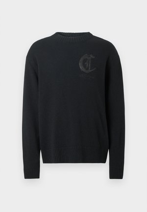 Crna pletena majica sa rebrastim izrezom i rukavima. Ima suptilan utisnuti logo na grudima i teksturirani pojas.