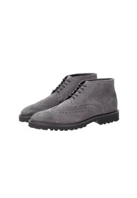 Botas de tobillo de ante gris con detalles de brogue, puntera redonda y suela de goma negra. Presentan cordones y una textura suave.