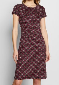 Abito a maniche corte, lunghezza ginocchio in tessuto bordeaux con un motivo a diamante e accenti floreali in tonalità crema, blu e verde.