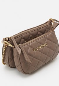 Borsa trapuntata marrone con accessori dorati, dotata di due scomparti con cerniera e il nome "VALENTINO" impresso sul davanti.