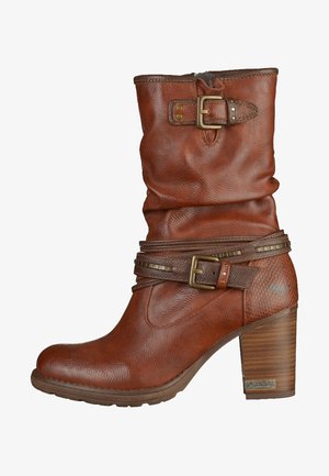 Hnědá kožená bota do půli lýtek se zúženým blokovým podpatkem, dvěma dekorativními mosaznými přezkami a texturovaným koženým detailem na podpatku.