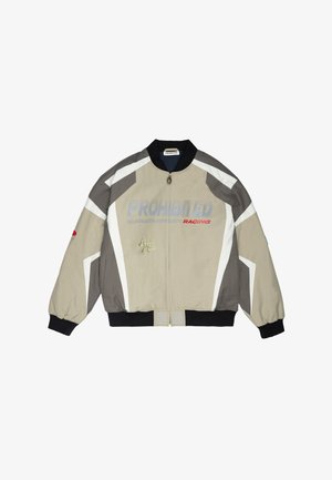 Veste de course beige et grise avec poignets et col noirs, fermeture éclair à l'avant, inscriptions « PROHIBITED RACING » et « Berlin Mile » sur le devant, et bandes blanches sur les manches.