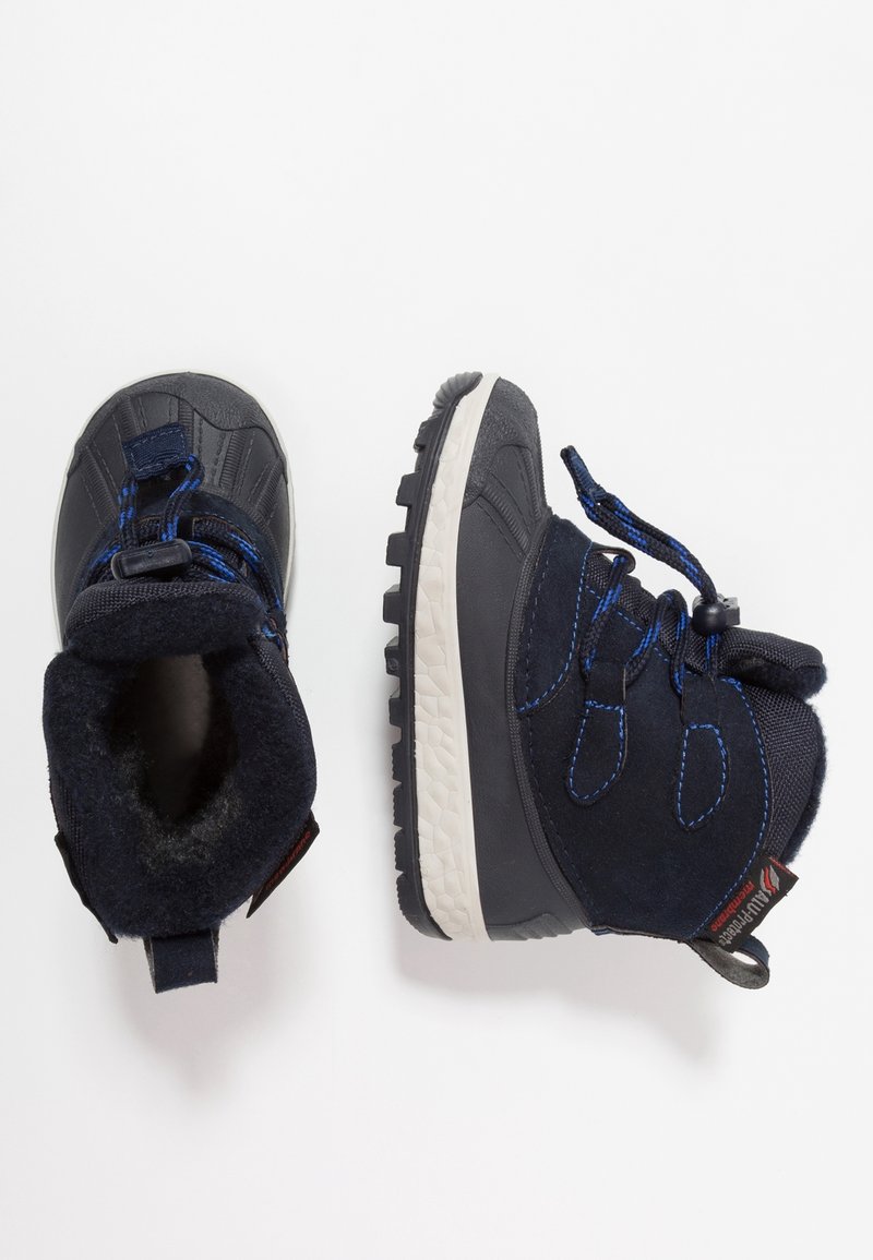 Botas de invierno azul marino con una parte superior texturizada, cordones elásticos y un borde acolchado. Cuentan con una suela de goma blanca con un patrón de dibujo.