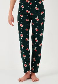 Pantalones de lounge verde con textura estriada que presentan un festivo diseño de oso polar y corazones en rojo y crema, con una cinturilla elástica y piernas ajustadas.