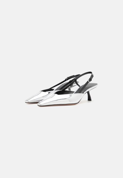 Sølv slingback hæle med spidse tæer og en lav sort hæl. Glat metalfinish med sorte stropper og et diskret trekantet udskæringsdesign.