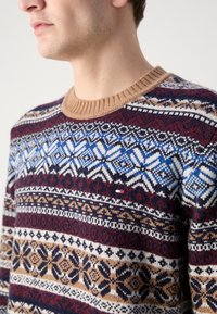 Strickpullover mit einem strukturierten Design, das blaue, burgunderfarbene, cremefarbene und braune geometrische Muster zeigt; gerippter beiger Kragen mit Logo-Detail der Marke.