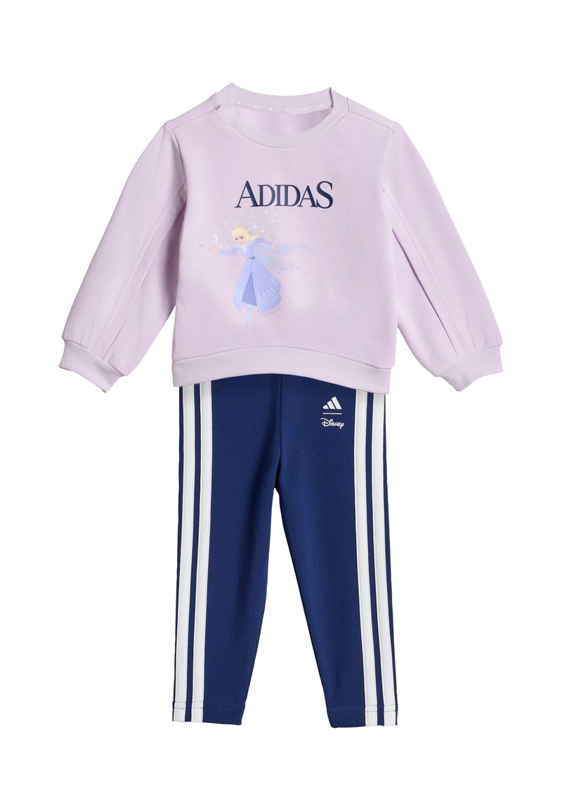 Sudadera lila con la palabra "ADIDAS" y un personaje de Disney, combinada con pantalones azul marino que tienen franjas laterales blancas y detalle del logo.