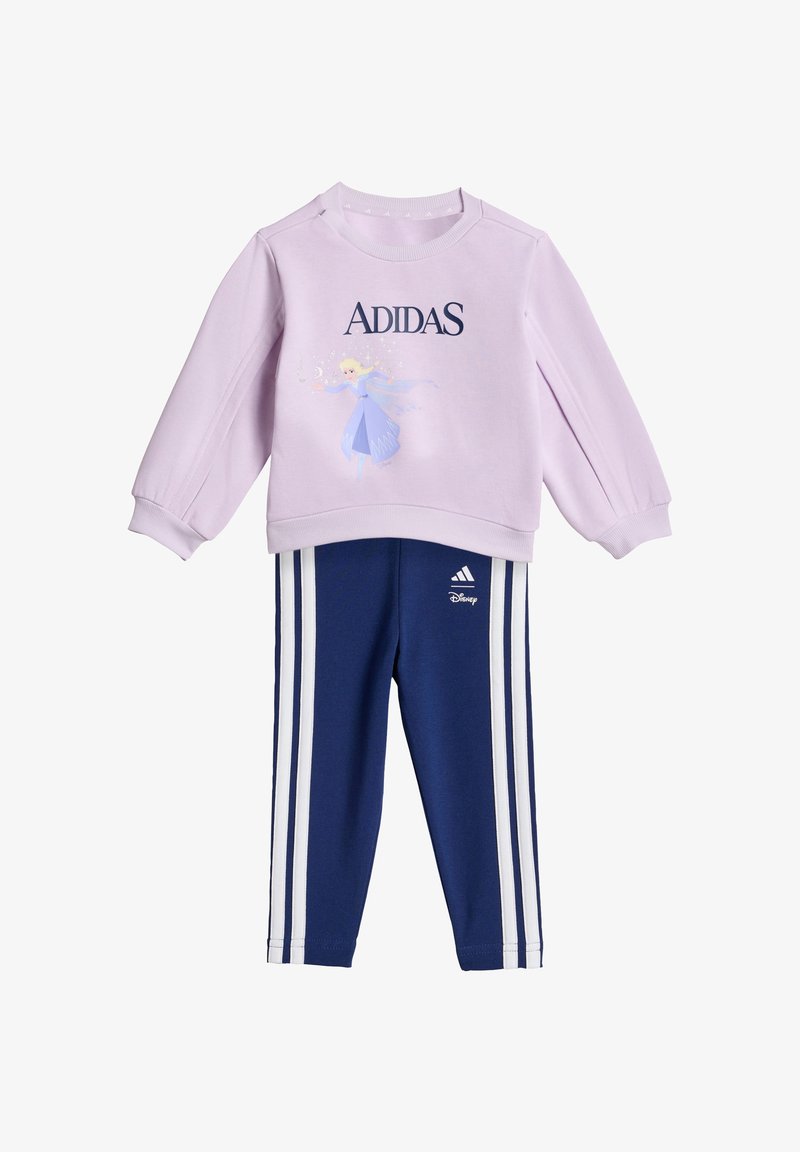 Sudadera lila con la palabra "ADIDAS" y un personaje de Disney, combinada con pantalones azul marino que tienen franjas laterales blancas y detalle del logo.