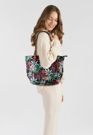 Floral-patterned tote bag in black, featuring vibrant pink and green plant designs, brown leather straps, and a subtle shiny finish.