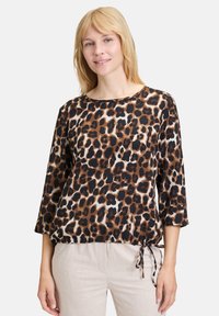 Leopardenmuster-Oberteil in Braun, Schwarz und Creme. Mit Dreiviertelärmeln und verstellbarem Kordelzugsaum für eine lässige Passform.