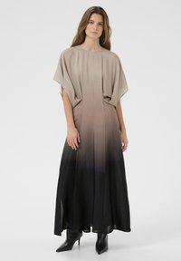 Dlhé, splývavé šaty s prechodom z béžovej na čiernu. Vyrobené z mäkkého materiálu s širokým, okrúhlym výstrihom a kimono rukávmi.