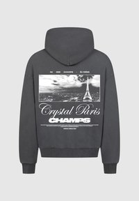 Felpa grigia con una stampa grafica della Torre Eiffel e testo. Il materiale sembra un misto cotone, con una consistenza morbida e polsini a costine.