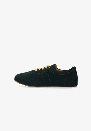 Baskets en suède noir avec des lacets jaunes et une semelle marron, présentées en profil latéral sur un fond blanc.