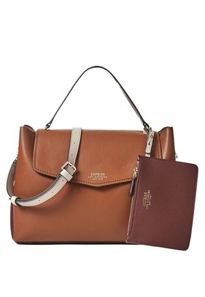 Sac à main en cuir marron Guess avec une sangle beige à boucle et une petite pochette zippée bordeaux assortie fixée sur un fond blanc.