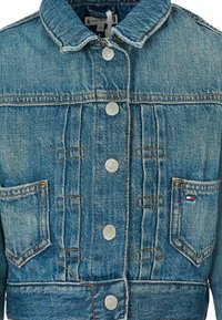 Giacca di jeans di color azzurro chiaro, con colletto a camicia, chiusura con bottoni in argento, due tasche sul petto e dettagli di cucitura.