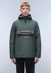 Groene waterdichte jas met een capuchon, voorzak en geborduurd merkgemerk. Heeft een Noors vlaggenpatch op de borst.