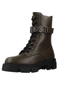 Stivale alla caviglia in pelle verde oliva con lacci neri, dettaglio con fibbia e suola in gomma spessa. Presenta una texture liscia e punta rotonda.