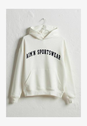 Kreem värvi kapuutsiga sviiter, millel on ees tasku ja tumesinise värvi kiri "AIM'N SPORTSWEAR" kaarekujulises stiilis. Pehme kangas, lõdva istuvusega.