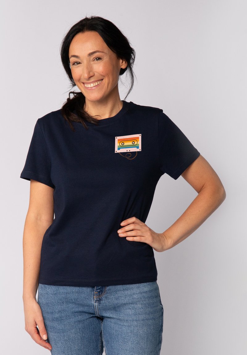 Marineblaue Baumwoll-T-Shirt mit grafischem Druck eines bunten Kassettenrecorders auf der linken Brust. Kurze Ärmel und ein entspanntes Fit-Design.