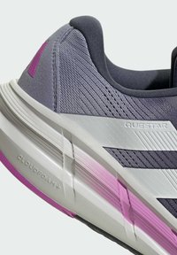 Sneaker in tessuto grigio con dettagli viola, caratterizzata da tomaia testurizzata, suola imbottita con la scritta "CLOUDFOAM+" e design con tre strisce bianche.