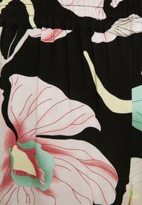 Květinová tkanina se velkými růžovými a zelenými květinami na černém pozadí, s detaily nabraného pasu a hladkou texturou.