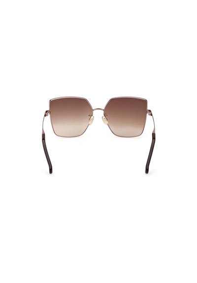 Gafas de sol hexagonales con un tinte marrón degradado. Montura de metal con varillas delgadas, puntas de acetato marrón oscuro y almohadillas nasales ajustables.