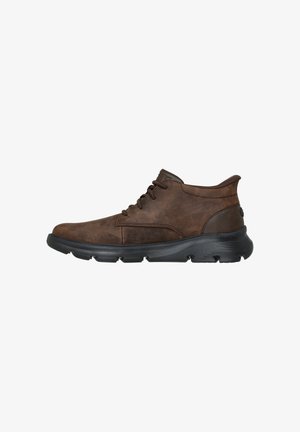 Bottines en cuir brun avec un bout arrondi, un design à lacets et une semelle en caoutchouc noir contrastant avec des accents texturés.