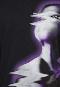Black graphic t-shirt featuring a wavy, distorted purple and white design. Text reads "HYPERSPACE" in a stylized font.