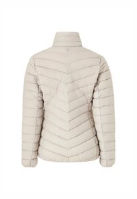 Lys beige pufferjakke med en chevron quiltet design, høj krave og elastiske manchetter. Glat tekstur med minimal hardware og branding.