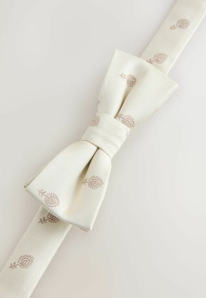 Ivoro spalvos audinio peteliškė su subtilia ruda gėlių siuvinėjimu ant šviesaus fono, tvarkingai surišta ir išdėstyta įstrižai.