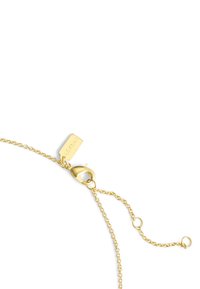 Bracelet en chaîne dorée avec un fermoir à homard et une longueur ajustable, comportant une petite étiquette estampillée "Coach". Maillons texturés à travers tout le bracelet.
