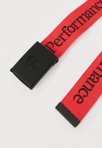 Raudonas nailoninis dirželis, ant kurio yra juodas atspausdintas tekstas ir juoda plastikinė sagtis su logotipu, skirtas reguliuojamam tvirtinimui.