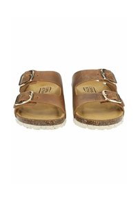 Bruine leren sandalen met twee verstelbare gespen, een kurken voetbed en een witte gespikkelde rubberen zool. Open teenontwerp voor ademend vermogen.