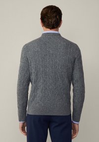 Grauer Strickpullover mit strukturiertem Kabelmuster, ausgestattet mit geripptem Saum und Bündchen. Lange Ärmel, runder Ausschnitt und figurbetonte Passform.