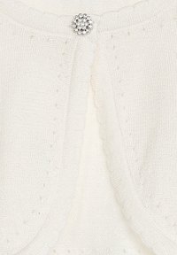 Weißer Strickcardigan mit gewelltem Rand und einem dekorativen, silberfarbenen, blumenförmigen Verschluss vorne. Leichte Textur.