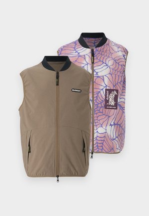 Reversible vest in brown fabric with side pockets; inner side features a pink-blue spider web pattern and brand logo patch.