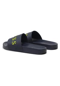 Navyblauwe schuursandalen met een gestructureerde rubberen zool, voorzien van een gedurfde gele logo over de bovenste band, open teen ontwerp.