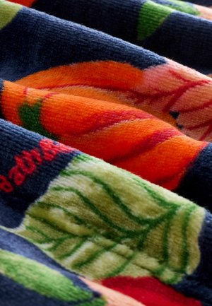 Colorful fabric featuring floral patterns. Textiles include orange, green, and navy hues with detailed textures and layered designs.