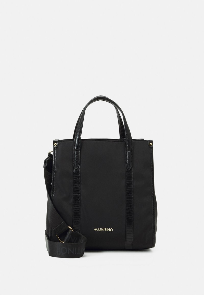 Svart tote-väska av slitstark tyg med eleganta detaljer i syntetläder, dubbla handtag upptill och en avtagbar axelrem. Guld-logotyp.