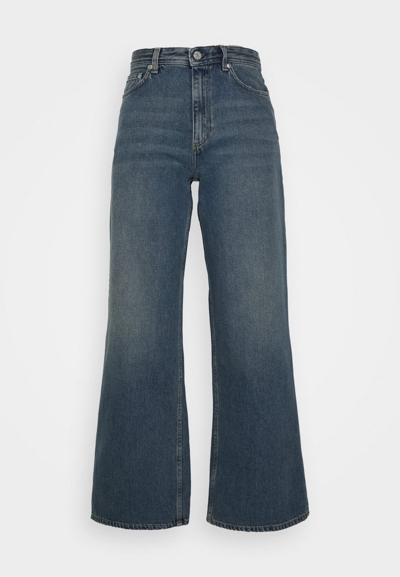 Jean denim bleu foncé à jambes larges, taille haute, fermeture par bouton et zip devant, et design cinq poches sur fond blanc.