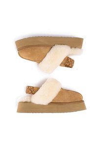 Tan suede slide sandals with a fluffy cream fur band and a patterned heel tab. The sole is thick and textured, designed for comfort.