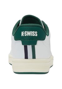 Adidași albi cu tabă de călcâi verde închis care afișează logo-ul "K-SWISS" și dungi verticale pe spate, văzuți din unghiul din spate.